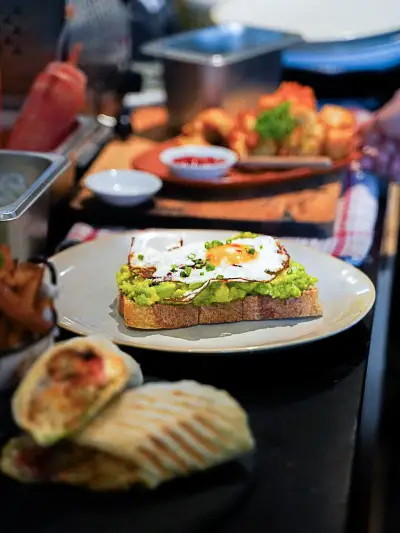 Avocado toast dengan telur mata sapi dan wrap panggang di meja Banyoo